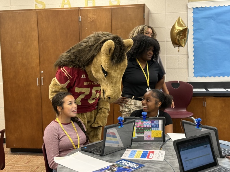 SAHS School Mascot with two students applying to college.