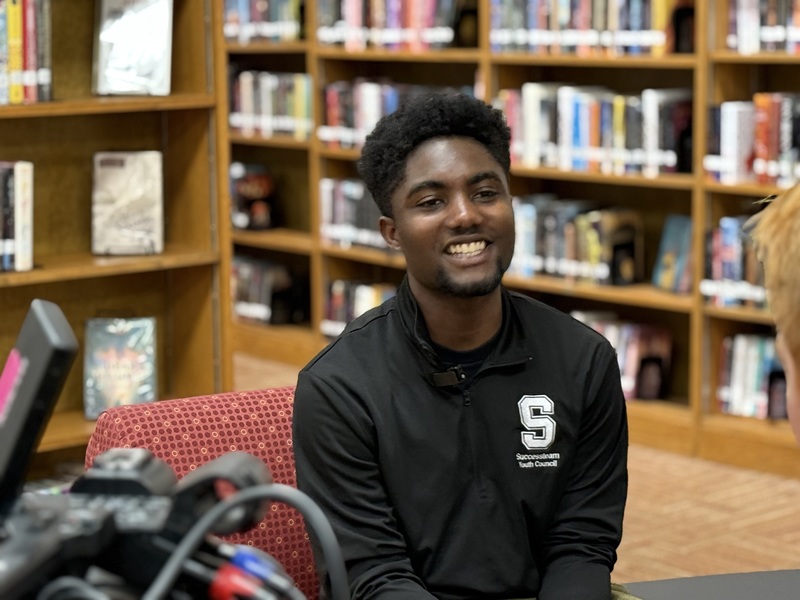High school senior being interviewed by media during college application month kickoff. 