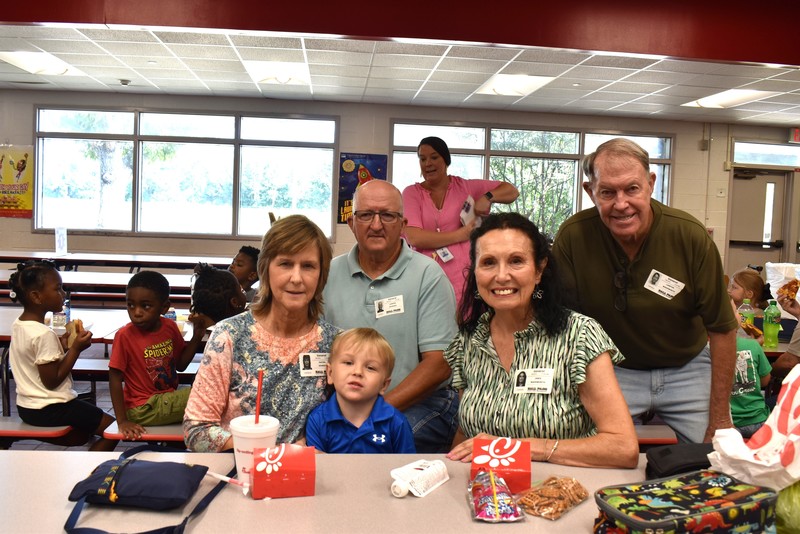 Grandparents and families at lunch with students.