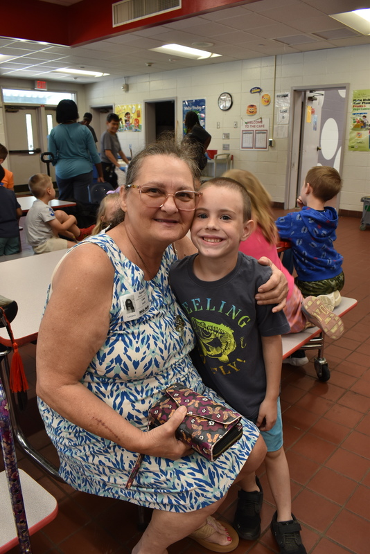 Grandparents and families at lunch with students.