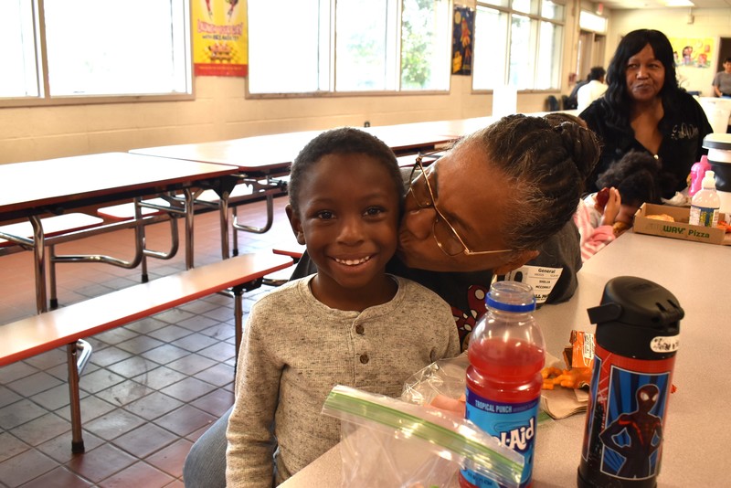 Grandparents and families at lunch with students.