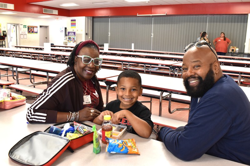 Grandparents and families at lunch with students.