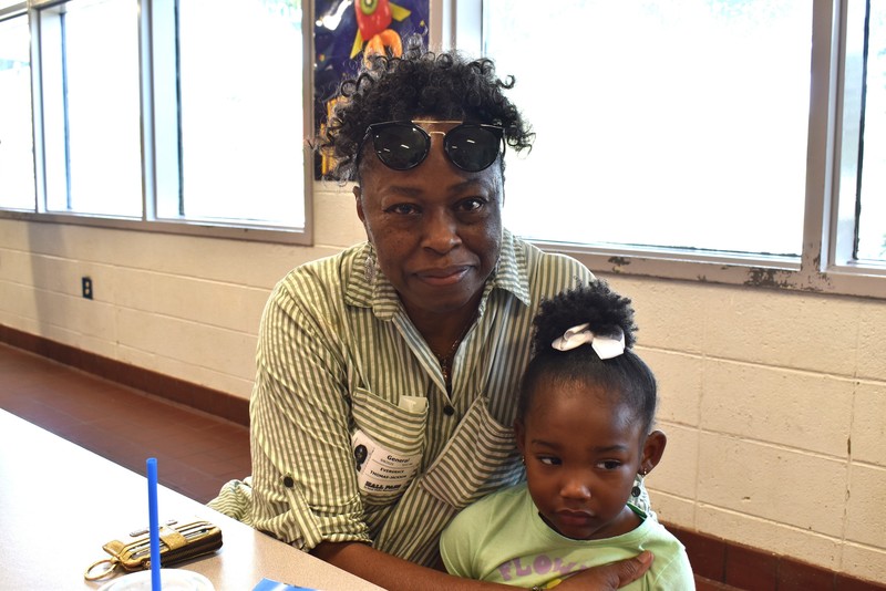 Grandparents and families at lunch with students.