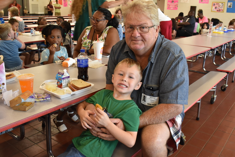 Grandparents and families at lunch with students.