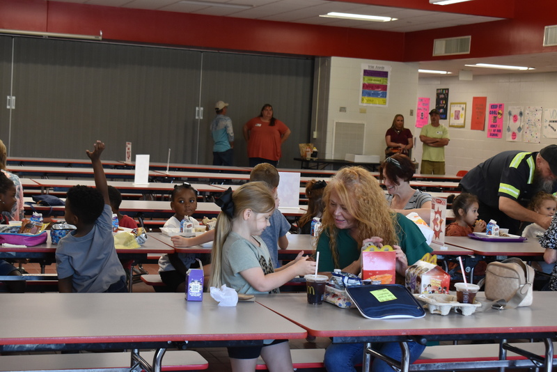 Grandparents and families at lunch with students.