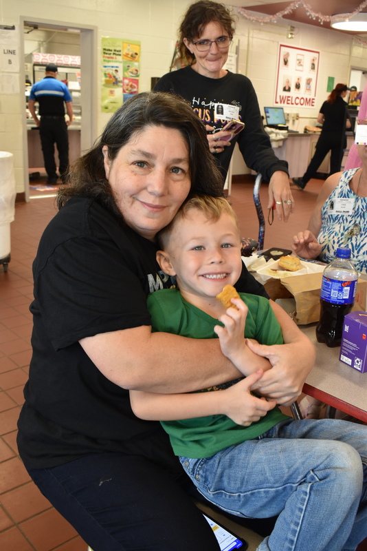 Grandparents and families at lunch with students.