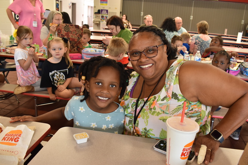 Grandparents and families at lunch with students.