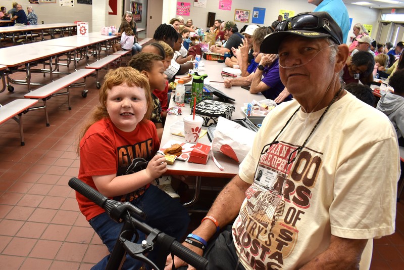 Grandparents and families at lunch with students.