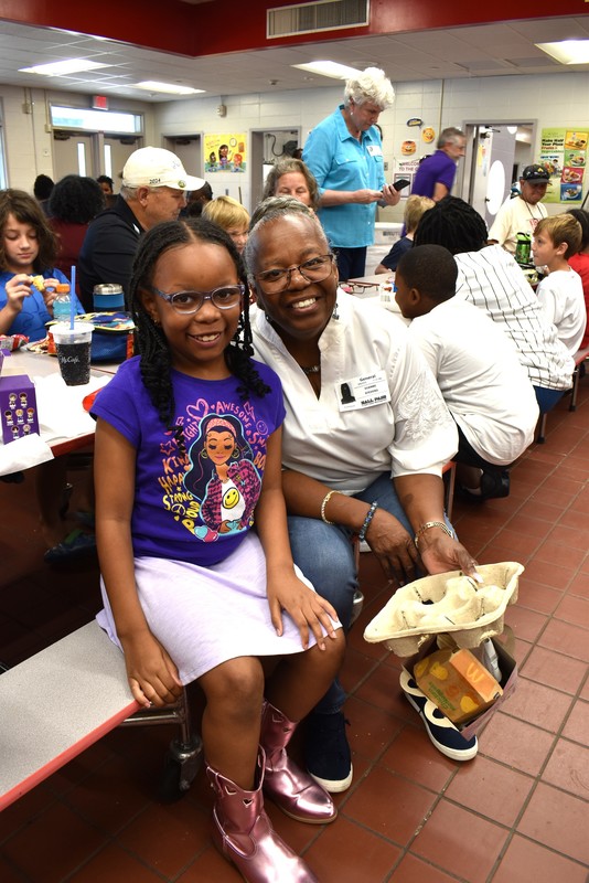 Grandparents and families at lunch with students.