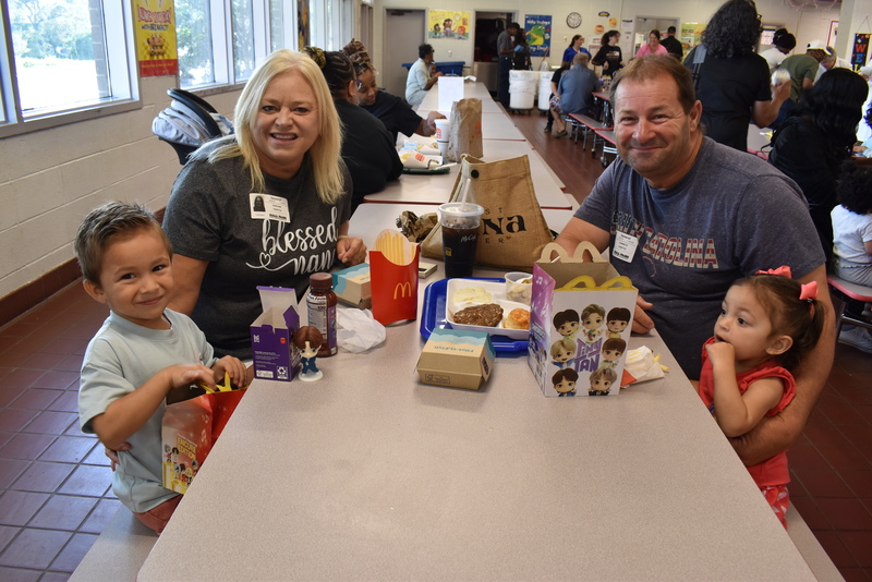 Grandparents and families at lunch with students.