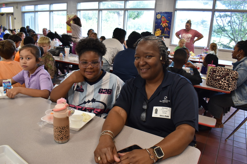 Grandparents and families at lunch with students.