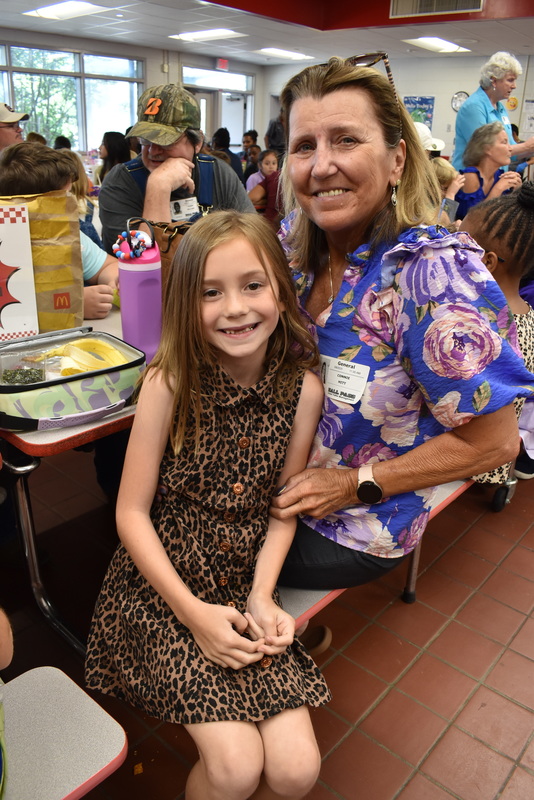 Grandparents and families at lunch with students.