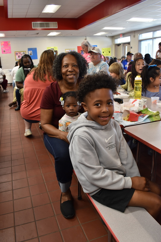 Grandparents and families at lunch with students.