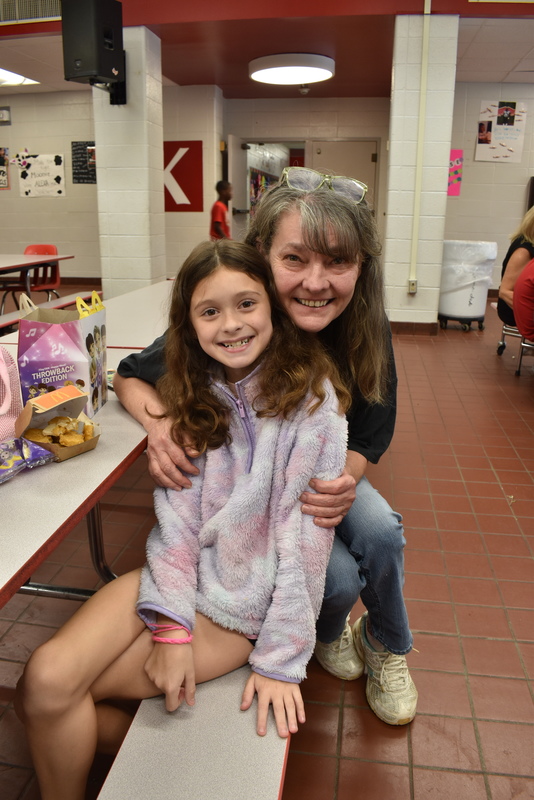 Grandparents and families at lunch with students.