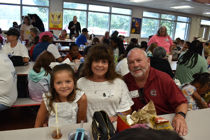 Grandparents and families at lunch with students.