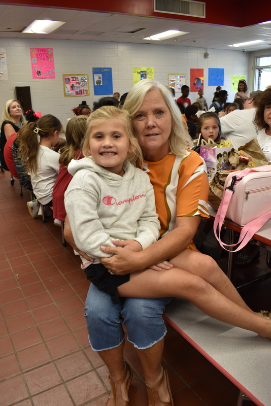 Grandparents and families at lunch with students.