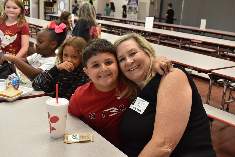 Grandparents and families at lunch with students.