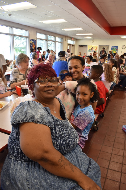 Grandparents and families at lunch with students.