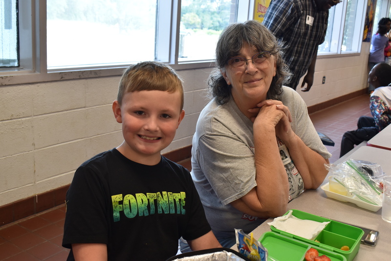 Grandparents and families at lunch with students.