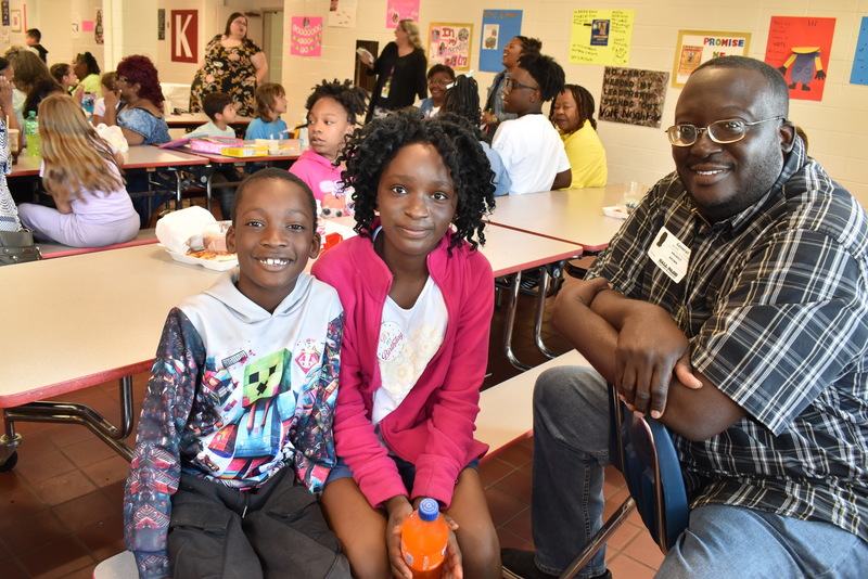 Grandparents and families at lunch with students.