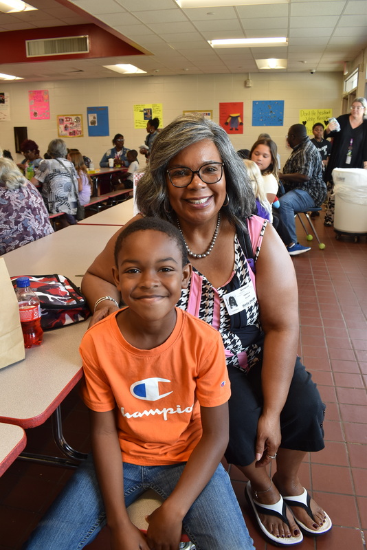 Grandparents and families at lunch with students.