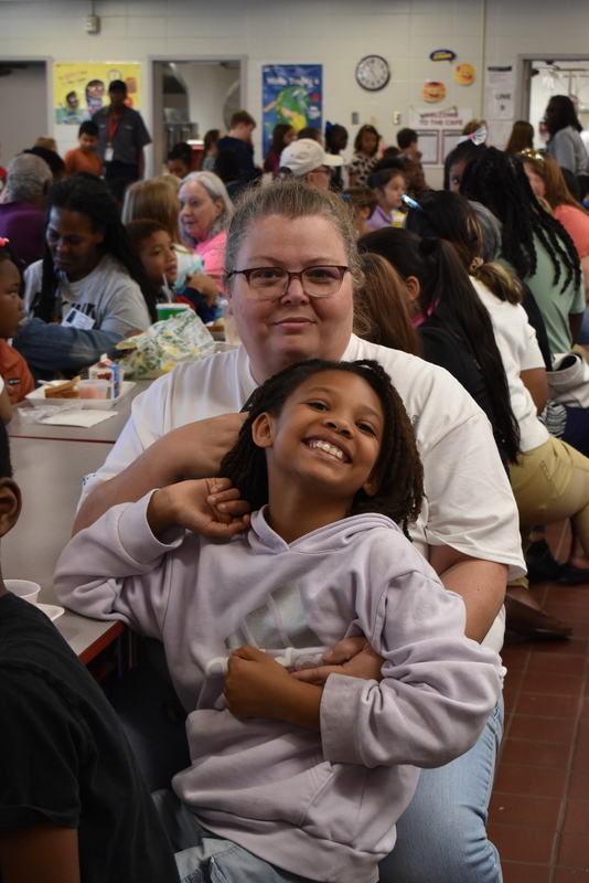 Grandparents and families at lunch with students.