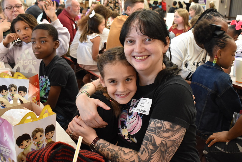 Grandparents and families at lunch with students.