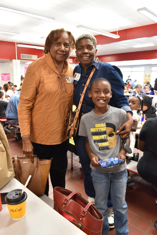 Grandparents and families at lunch with students.