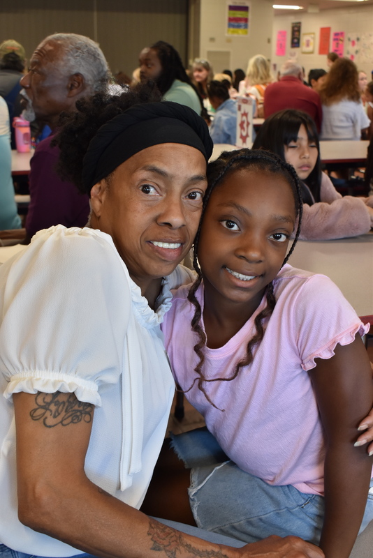 Grandparents and families at lunch with students.