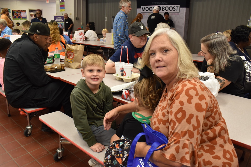 Grandparents and families at lunch with students.