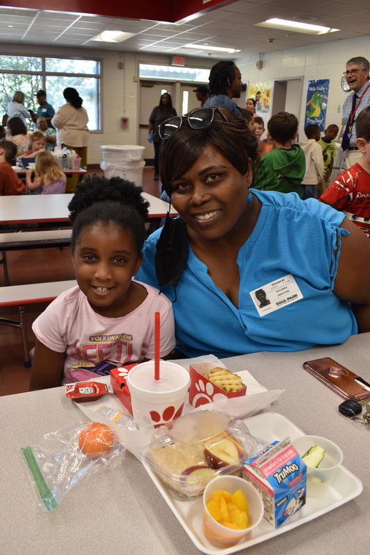 Grandparents and families at lunch with students.