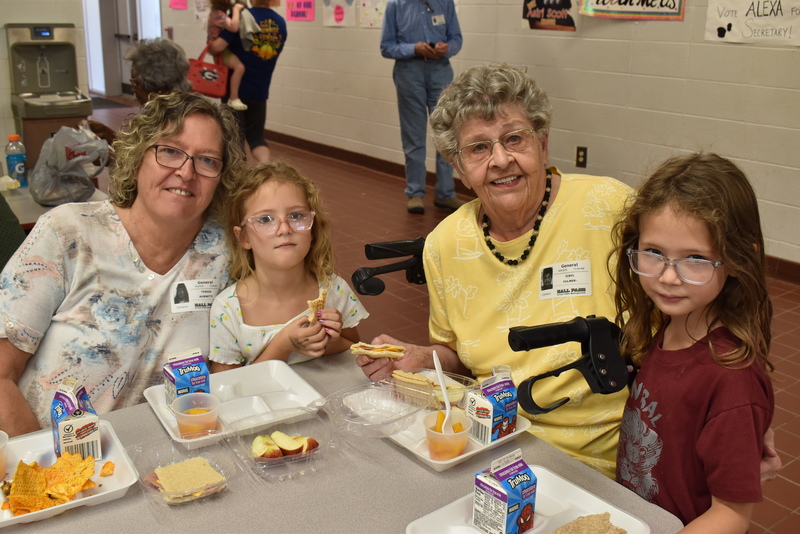 Grandparents and families at lunch with students.