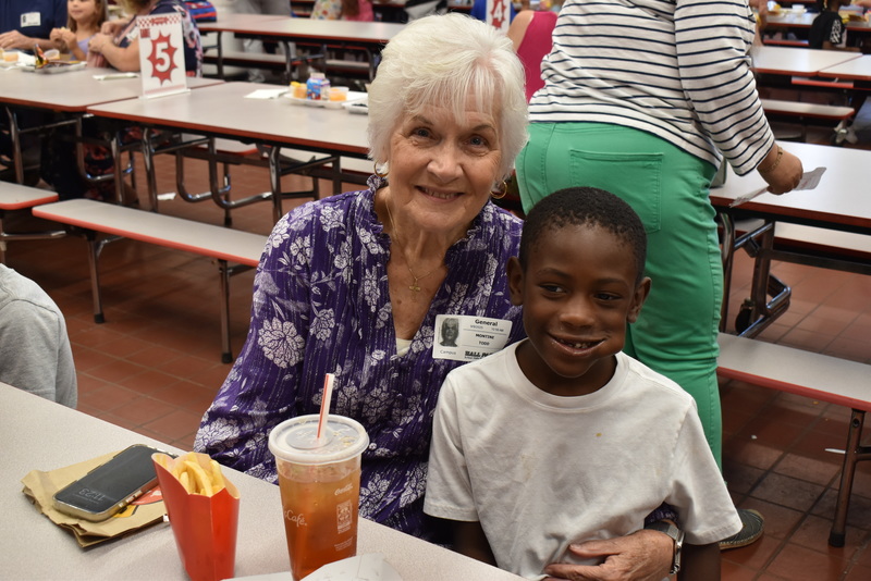 Grandparents and families at lunch with students.