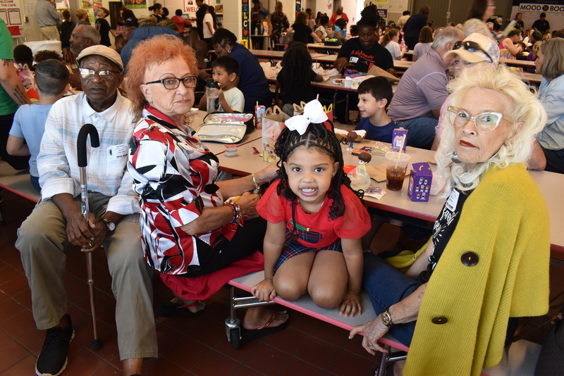 Grandparents and families at lunch with students.
