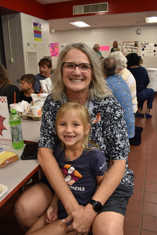Grandparents and families at lunch with students.