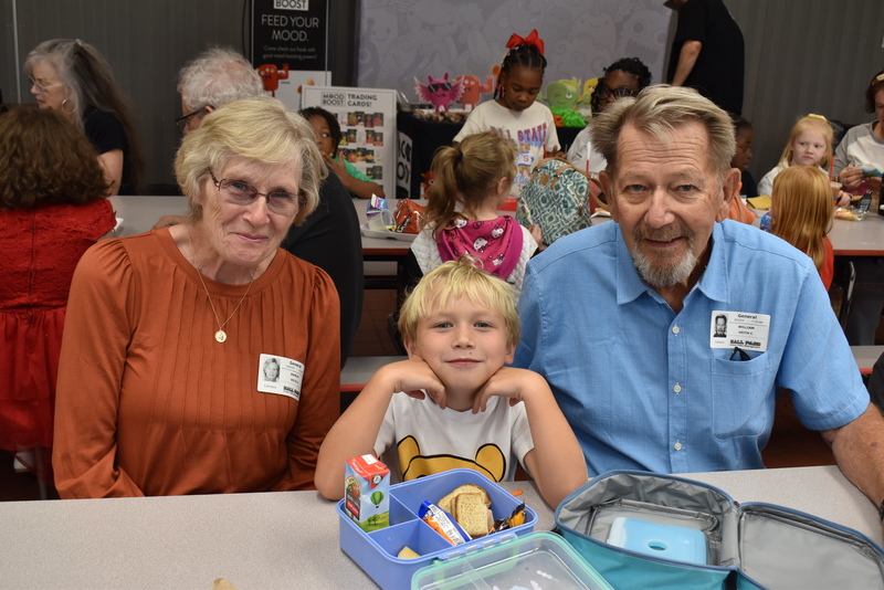 Grandparents and families at lunch with students.