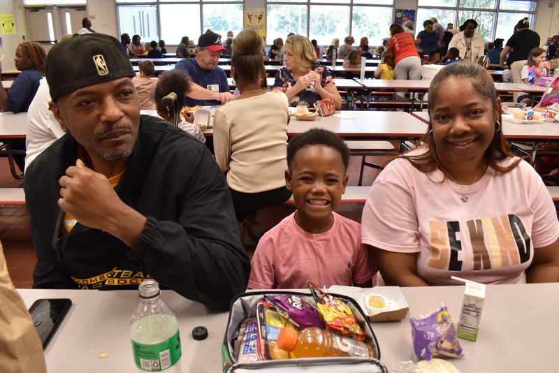 Grandparents and families at lunch with students.