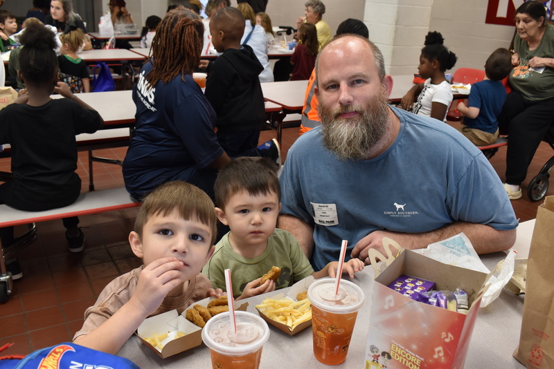 Grandparents and families at lunch with students.