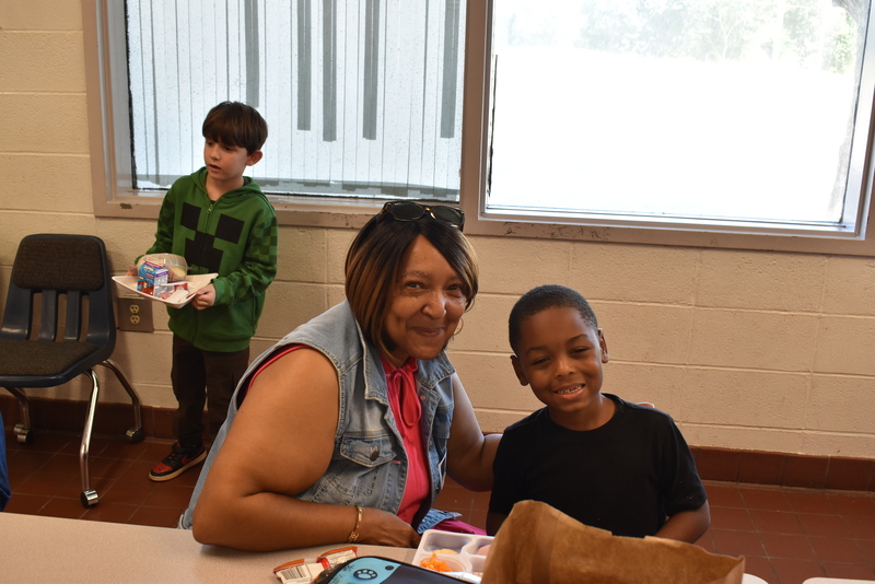 Grandparents and families at lunch with students.