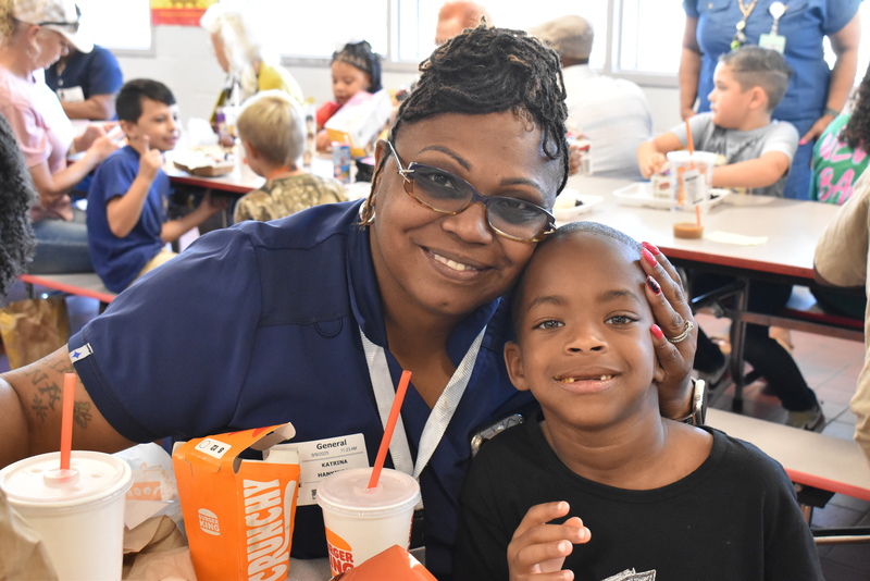 Grandparents and families at lunch with students.