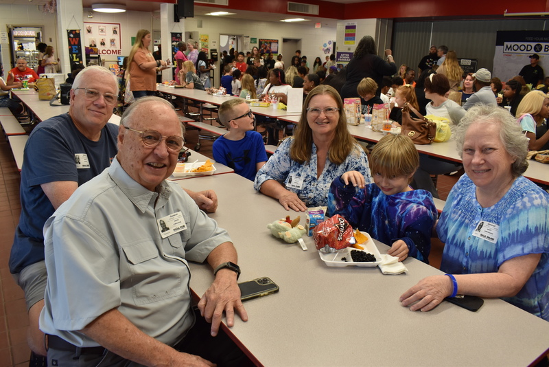 Grandparents and families at lunch with students.