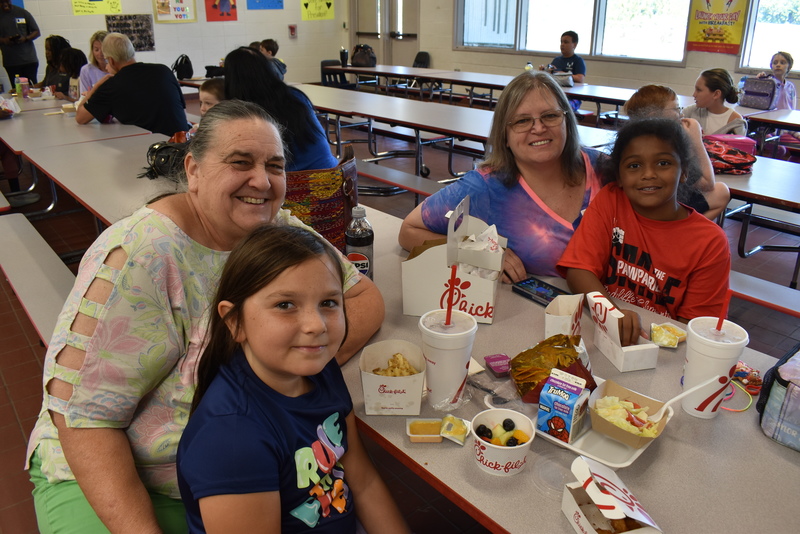 Grandparents and families at lunch with students.