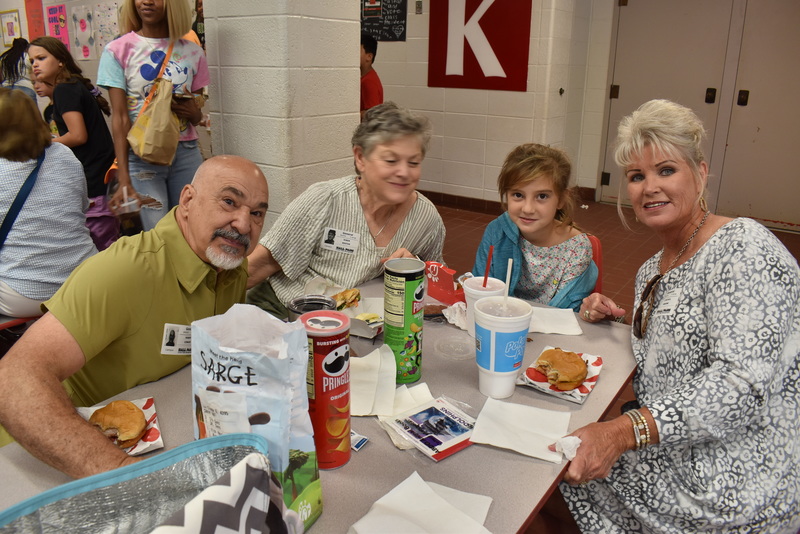 Grandparents and families at lunch with students.