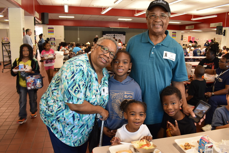 Grandparents and families at lunch with students.