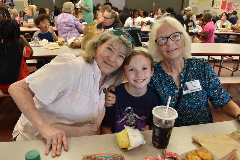 Grandparents and families at lunch with students.