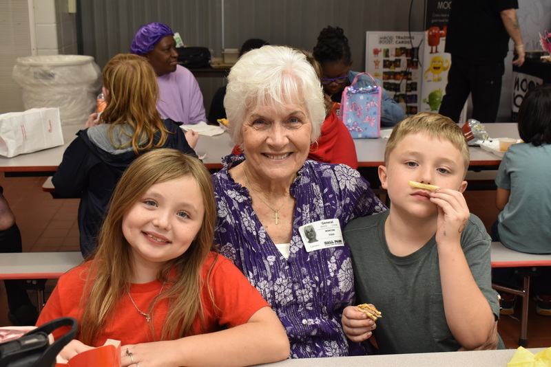 Grandparents and families at lunch with students.