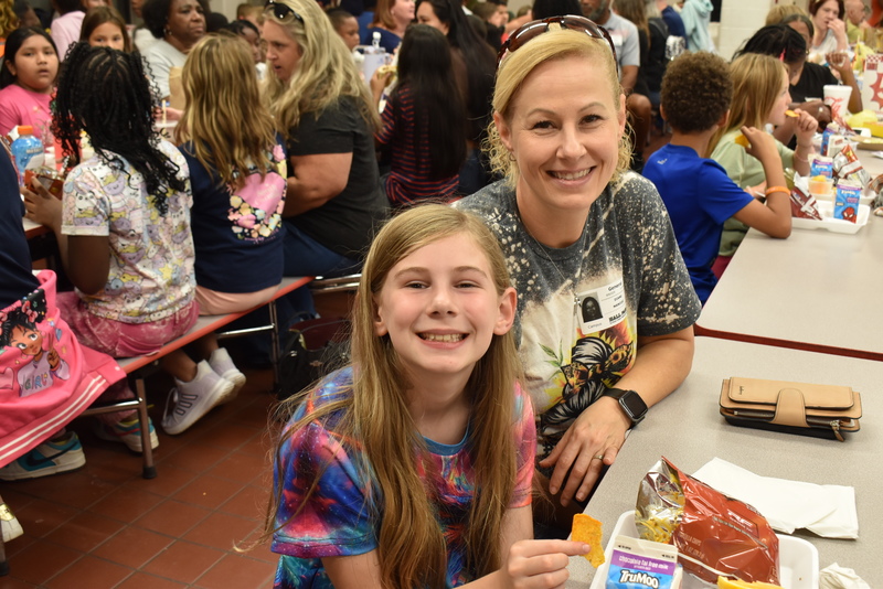 Grandparents and families at lunch with students.
