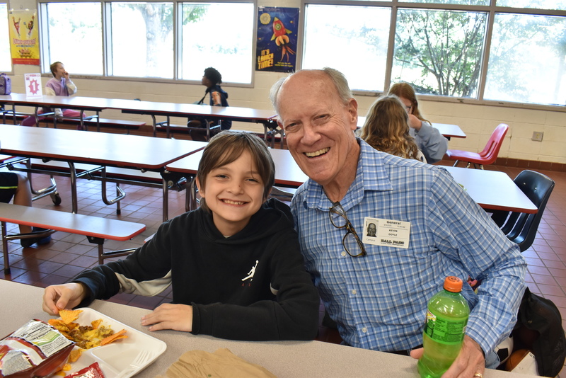 Grandparents and families at lunch with students.