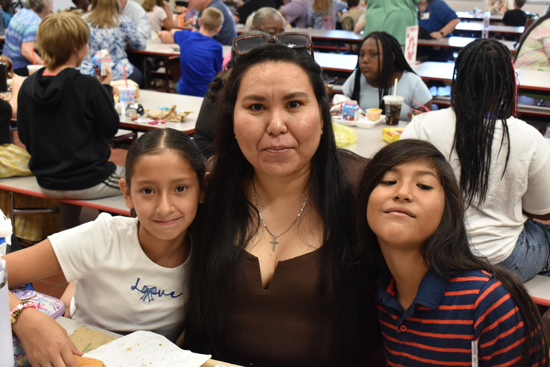 Grandparents and families at lunch with students.