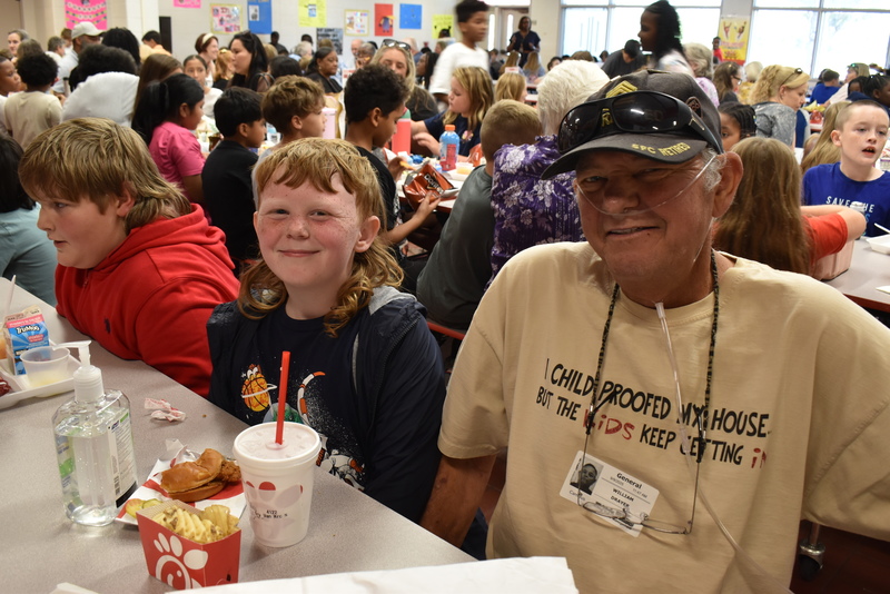 Grandparents and families at lunch with students.